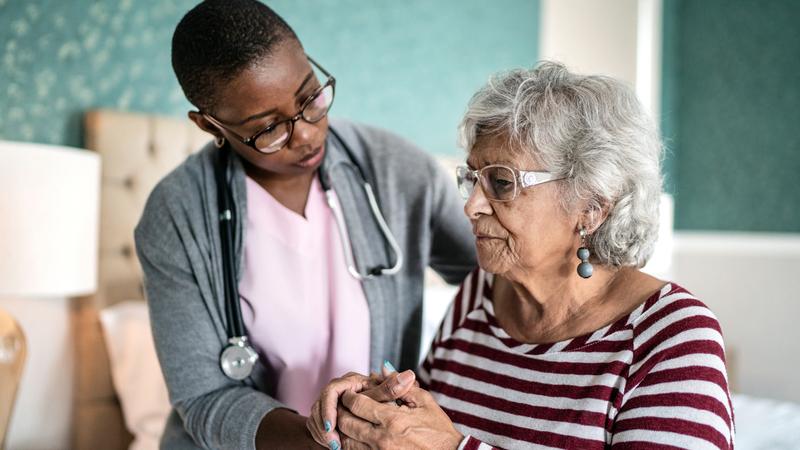 A nurse provides compassionate care for an elderly female patient.