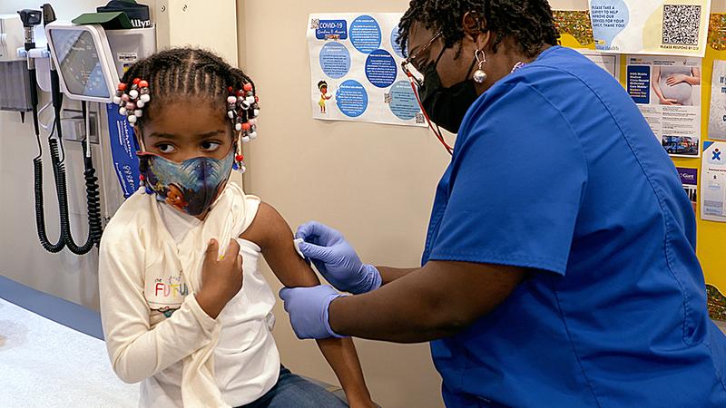 A young girl receives a vaccination at the mobile health center truck at MedStar Health.