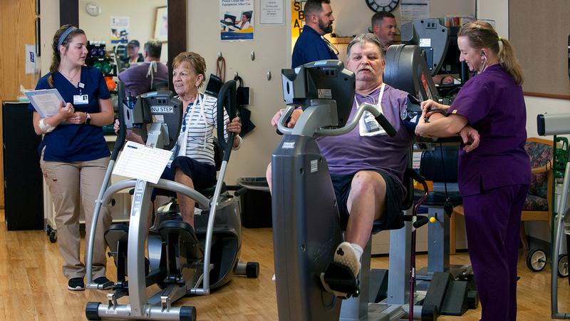 Patients work with therapists in a cardiac rehabilitation gym.