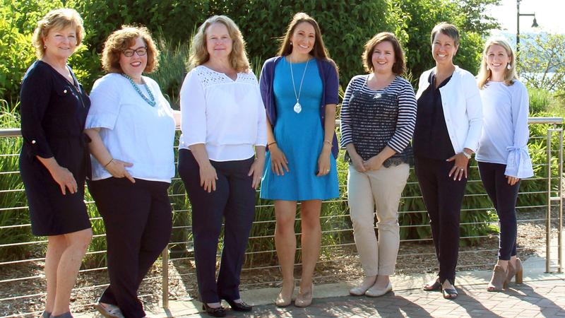 A group of MedStar Health marketing and public relations associates stands together for a group photo outdoors. 