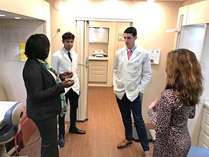 A group of healthcare professionals holds a stand-up meeting in side the mobile health truck at MedStar Health.