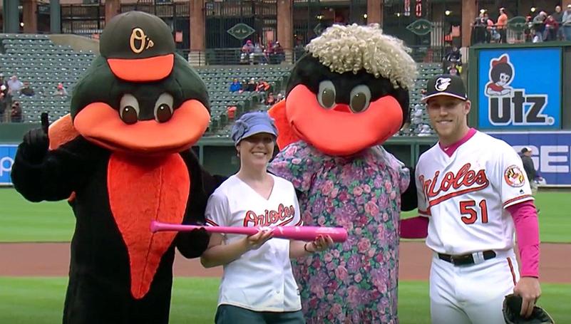 Melanie Vohs poses with the Orioles' mascots at Camden Yards.