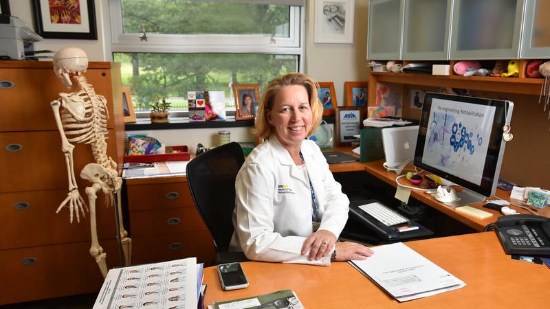 Dr Suzanne Groah sits at her desk and poses for a photo.