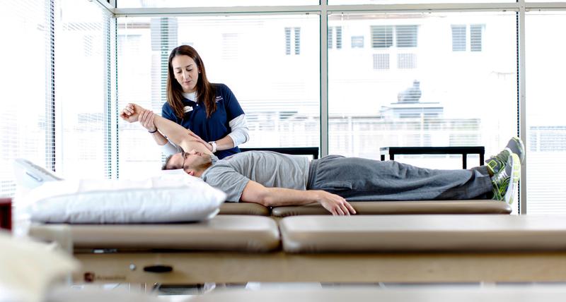 A physical therapist works with a patient during a session at MedStar Health.