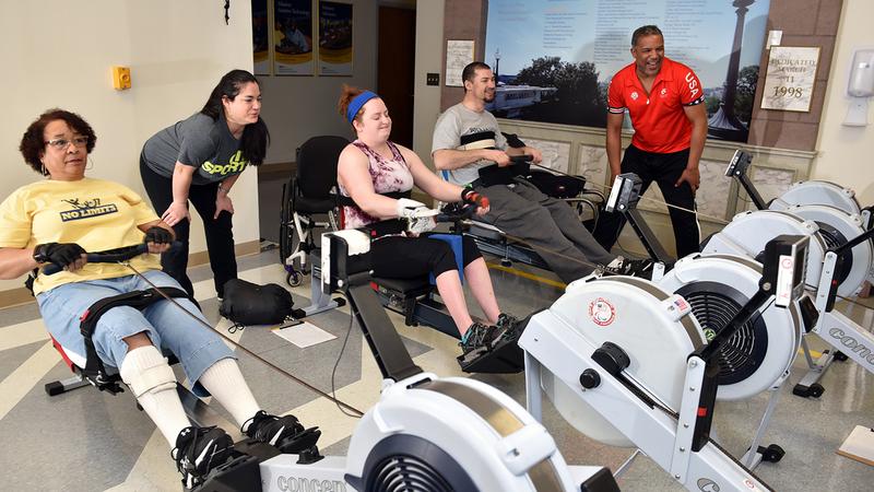 Therapists at MedStar National Rehabilitation Hospital work with patients who are using rowing machines in a rehabilitation gym.