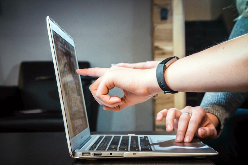 Close up photo of hands and a laptop computer.