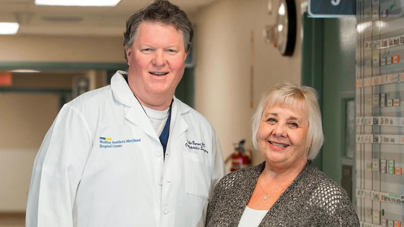 Dr John Byrne stands with Anita Persing after a successful knee replacement surgery at MedStar Health.