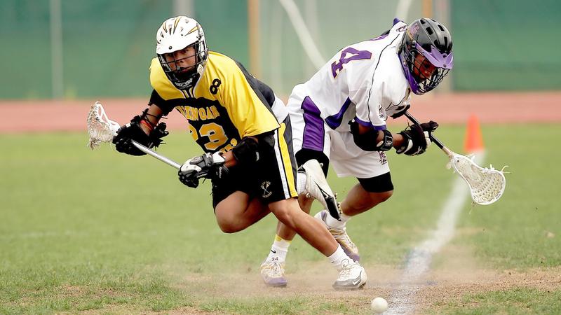 Two lacrosse players on the field.