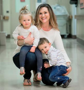 Melanie Bush and her 2 young children pose for a photo in a hospital hallway at MedStar Health.