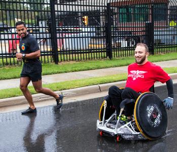 A runner and a wheelchair racer participate in the 2018 Super H Run Walk Cycle event.