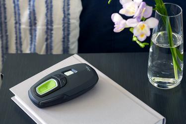 A remote control module for the Inspire sleep apnea implant device is shown sitting on a bedside table.