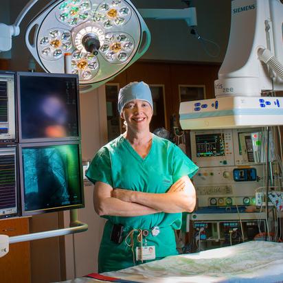 Dr Susan O'Donoghue stands with her arms crossed in the electrophysiology lab at MedStar Washington Hospital Center.