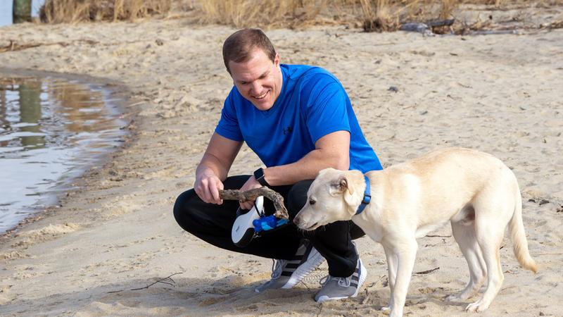 Chris Vass and his dog on a beach.