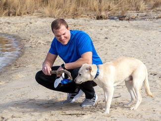 Chris Vass and his dog on a beach.