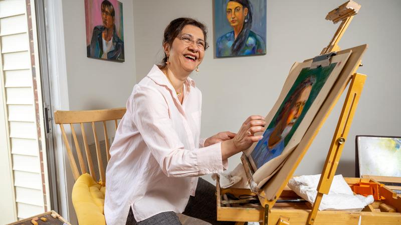 Nahed El Kassar paints a portrait in her home art studio.
