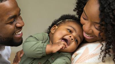 A young family laughs together.