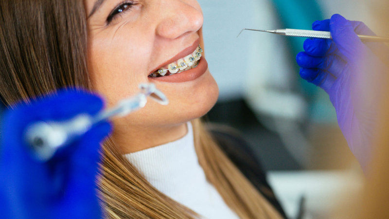 A girl wearing braces visits the dentist.