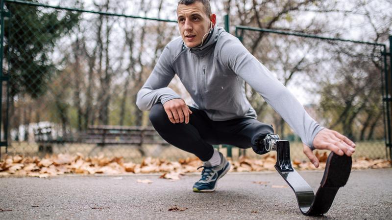 A man with a prosthetic leg stretches before going on a run.