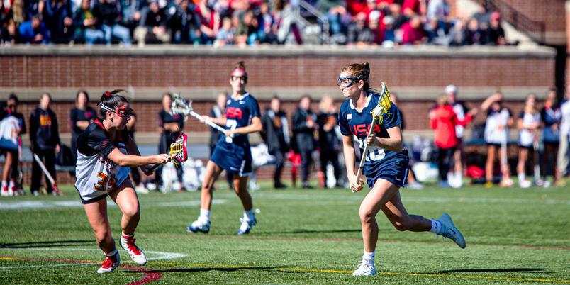 A team of USA Lacrosse women play in a game.