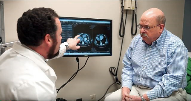 Dr Benjamin Weinberg consults with a patient and shows a diagnostic scan on a computer screen.