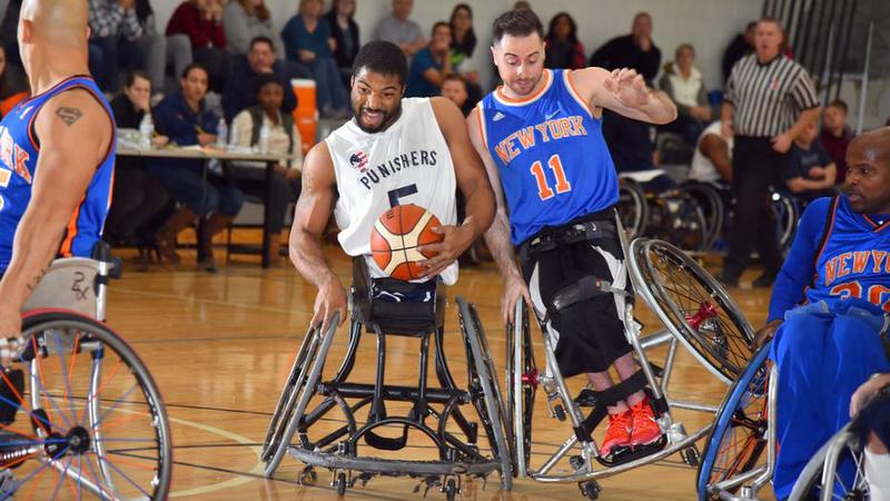 Two wheelchair basketball players compete during a game.