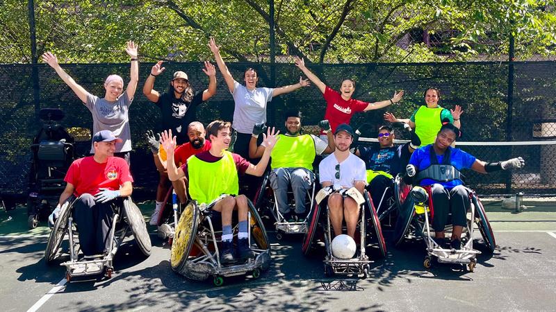 A group of athletes in MedStar Health's adaptive fitness program pose for a photo outdoors.