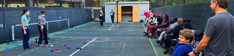 A group of athletes in MedStar Health's adaptive fitness program play boccia outdoors.