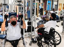 Clients in MedStar Health's adaptive fitness program lift weights in a fitness gym.