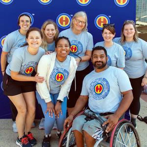 A group of athletes in MedStar Health's adaptive fitness program pose for a photo outdoors.