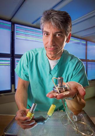 NAJJAR_Samer_holding LVAD device_portrait_cardiac catheterization lab_MWHC_WASHINGTON_vert