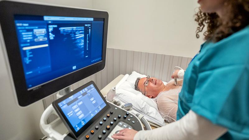 A medical technician performs a diagnostic imaging test on a patient.