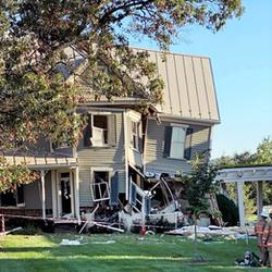 Photo of a green house and half of it is collapsed after an explosion.