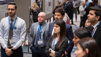Attendees look at abstracts during the 2024 Research Symposium which featured Dr. Anthony Fauci