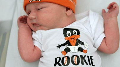 A newborn baby, wearing a Baltimore Orioles hat.