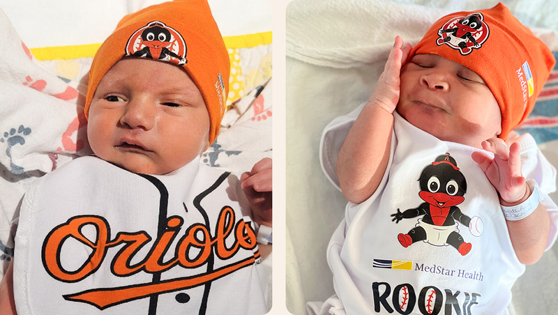 A newborn baby, wearing a Baltimore Orioles hat.