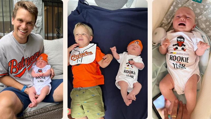 A newborn baby, wearing a Baltimore Orioles hat posing for photos with family.