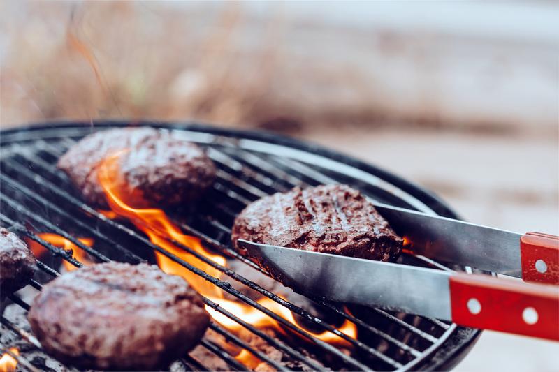 Meat cooking on a backyard grill.