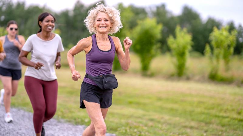 A group of women exercise together in a park.