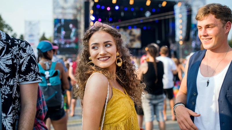 A young woman looks over her shoulder in an urban setting.