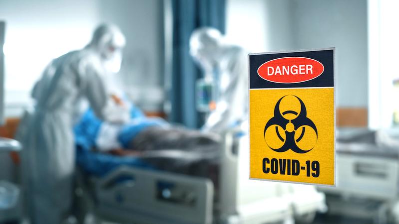 世界杯欧洲区附加赛卫生保健工作者穿着全身保护PPE治疗COVID-19患者在医院的房间。