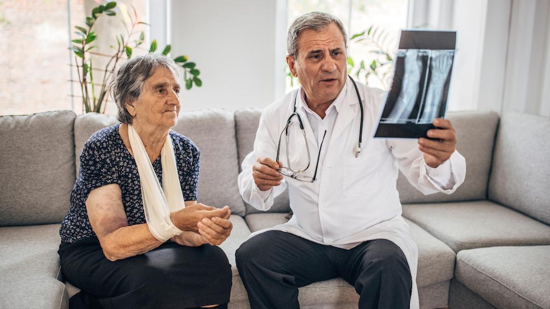 A doctor and patient sit together and look at an xray film.