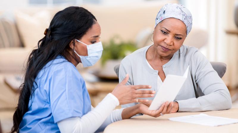 A nurse talks with a female cancer patient.