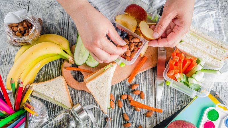 Close up photo of a person's hands assembling a healthy lunch.