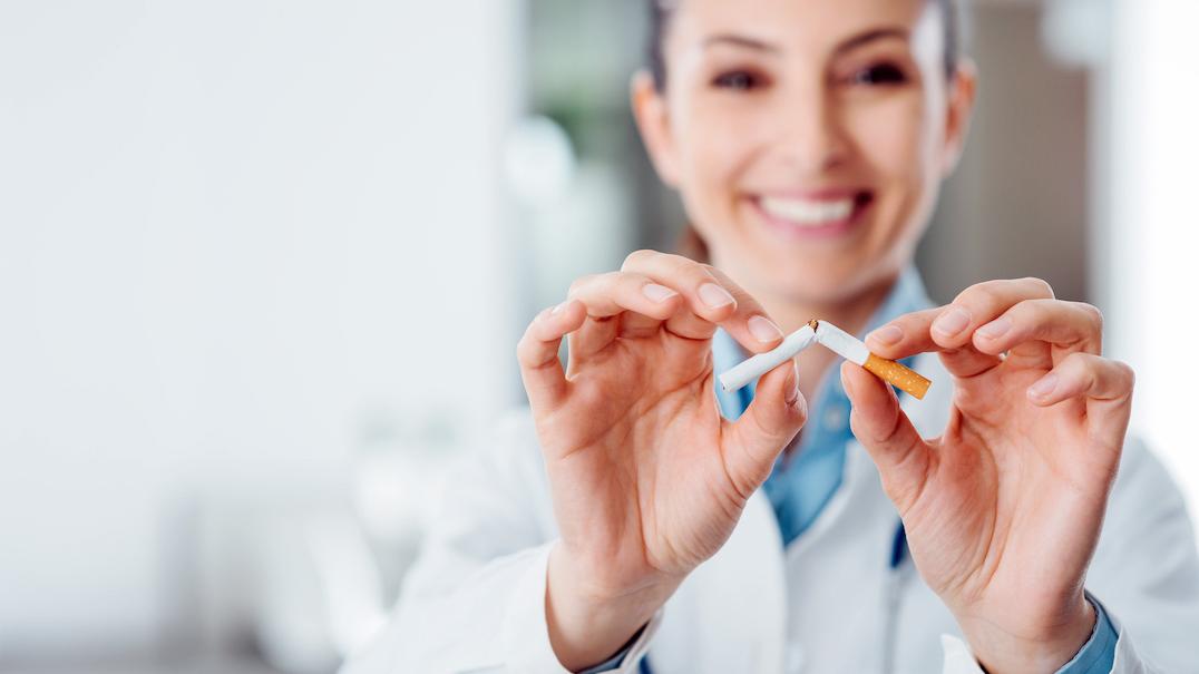 A nurse breaks a cigarette in half.