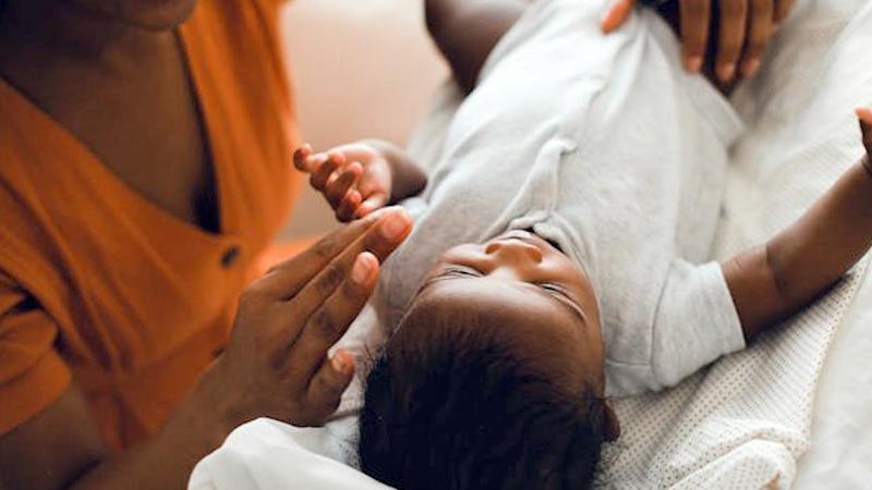 Close up photo of a newborn baby being comforted by the mother.