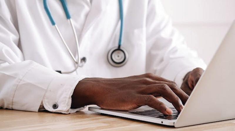 Close up photo of hands typing on a laptop computer.