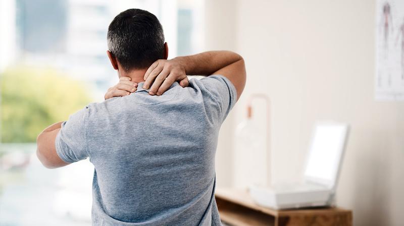 A man massages his painful neck.