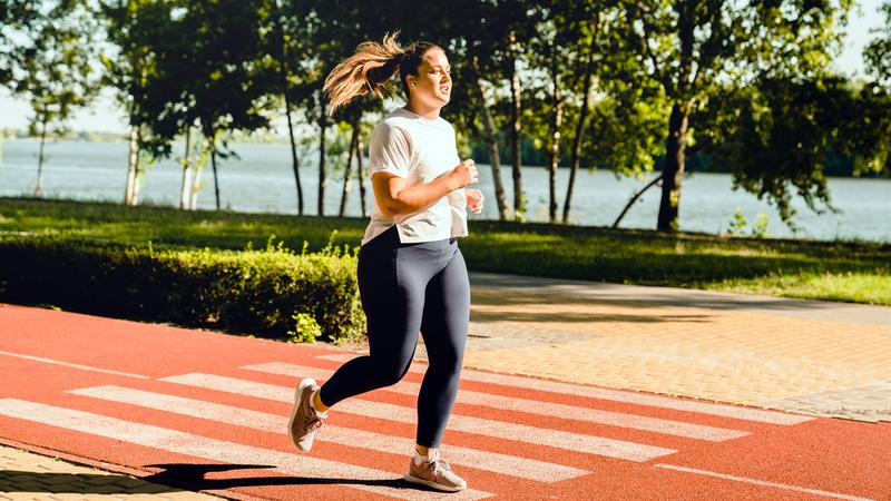 A young woman runs outdoors for fitness.