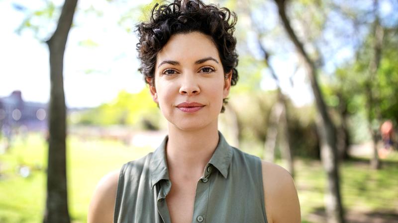 Portrait of a confident young woman standing at the park. Beautiful female in casuals looking at camera.