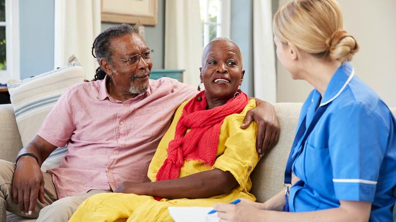 A nurse talks with a patient and her husband.